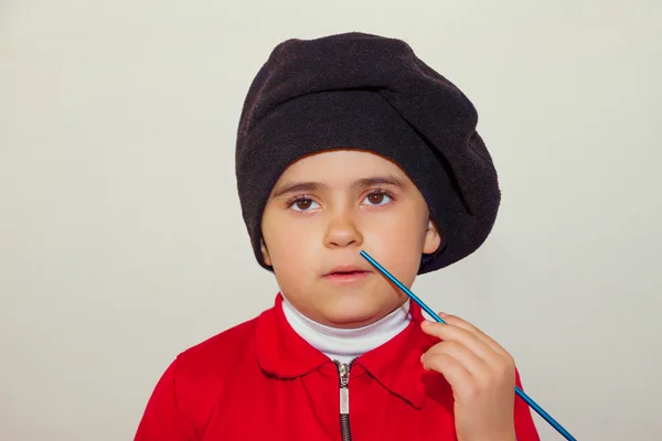 Un garçon avec un béret sur la tête et un pinceau à la main — Photo