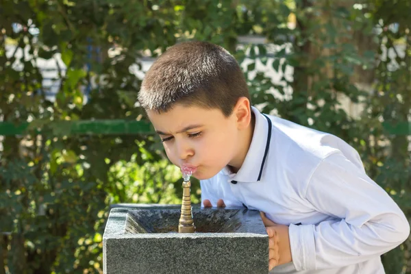 Мальчик пьет воду из Пулпулака — стоковое фото