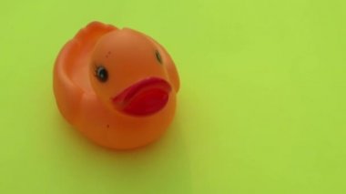 Masadaki yüksek açılı lastik ördek görüntüsü. Açık sarı arkaplanda tek pembe renkli plastik ördek izole edilmiş. Masa üstü görünümü. Metin için alanı kopyala. 