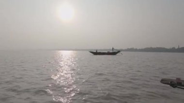 Siluet Tekne, gün batımında açık gökyüzü arka planına karşı Horizon Nehri 'nden geçiyor. Güneş batıyor..