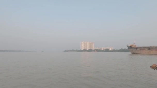 ガンジス川を航行中のコンテナ船キディプール港を出港後 日没の背景で澄んだ空に対するフェリーボートの旅から撮影した映像 コルカタインド2021年10月 — ストック動画