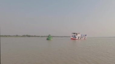 Nehrin ortasındaki balıkçı teknesine bağlanmış bir demirle Sunset 'in açık gökyüzü ufkuna karşı. Achipur Fırlatma Ghat, Kolkata Batı Bengal Hindistan, Güney Asya Pasifik.