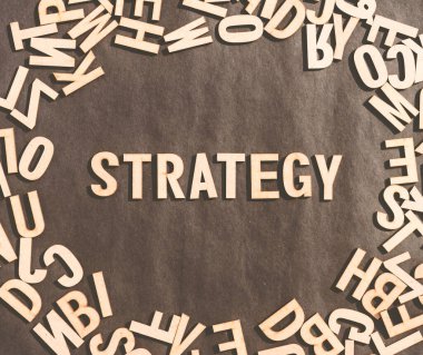 Tahta Küp Alfabesindeki Strateji Sözcüğü Kırsal bir arka planda Üst Görünüm Harfleri.