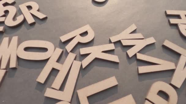 木製のキューブでデコの仕事アルファベット文字トップビュー素朴な紙の背景に表示 — ストック動画