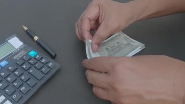 İnsan eli, hesap makinesine ve masaya yerleştirilmiş bir kaleme karşı 500 rupi Hindistan parası sayıyor. Yüksek açı. Kapatın. Bankacılık İşletme Finans Arkaplanı.