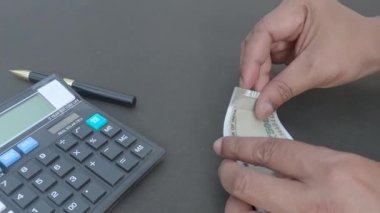 İnsan eli, hesap makinesine ve masaya yerleştirilmiş bir kaleme karşı 500 rupi Hindistan parası sayıyor. Yüksek açı. Kapatın. Bankacılık İşletme Finans Arkaplanı.