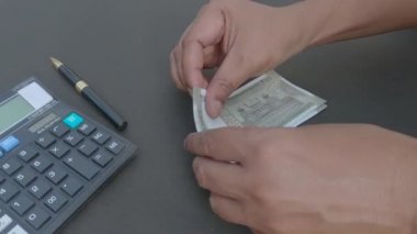 İnsan eli, hesap makinesine ve masaya yerleştirilmiş bir kaleme karşı 500 rupi Hindistan parası sayıyor. Yüksek açı. Kapatın. Bankacılık İşletme Finans Arkaplanı.