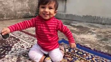 Mutlu şirin bebek gülüyor ve gülen kalbi sallıyor. Portreyi kapat. Hint etnik kökeni. Ön manzara. Metin için alanı kopyala.