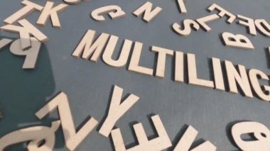 Alfabe harflerinin tahta bloklarından gelen çok dilli kelimeyle ateş edildi. Yüksek Açı Görünümü. 