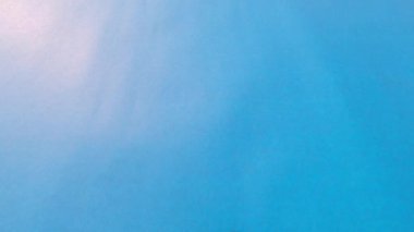 İzole edilmiş mavi arka plana beyaz çapa yerleştiriliyor. Denizcilik teması. Boşluğu Kopyala.