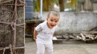Şirin, akıllı, yaramaz bebek komiklik yapıyor ve kameraya bakıyor. Mutlu bebek geçmişi.