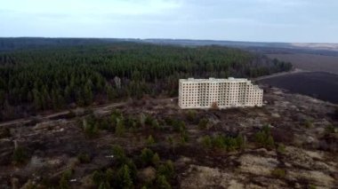 View from a height of a large unfinished house on the edge of the forest