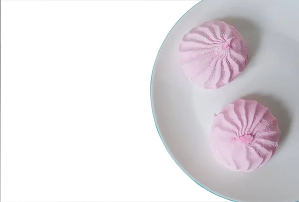 Zwei rosa Zephyre auf einem Teller auf weißem Hintergrund — Stockfoto