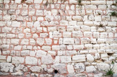 Taş duvar. Taştan yapılmış eski bir duvar. Eskimiş doku. Tuğla. Seçici odak.