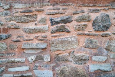 Taş duvar. Taştan yapılmış eski bir duvar. Eskimiş doku. Tuğla. Seçici odak.