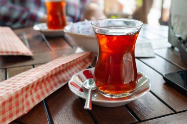 Türk çayı. Kafedeki bir masada bir bardak çay. Geleneksel Türk bardağında çay. Seçici yumuşak odak.