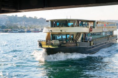 İstanbul 'daki Golden Horn Körfezi' ndeki köprünün altından bir turist gemisi geçiyor. İstanbul. Türkiye - 09.25.2021.