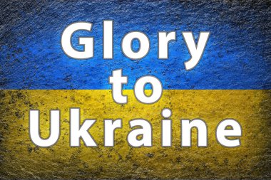 Ukrayna bayrağı. Beyaz sloganı GLORY to UKRAINE olan Ukrayna bayrağı kaba bir yüzeye boyanmıştır. Yaratıcı arkaplan.