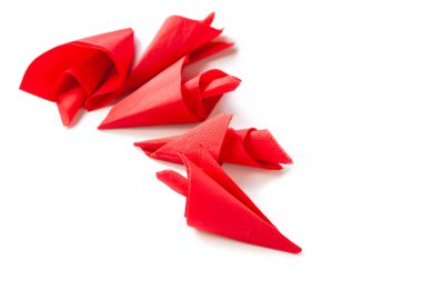 Kırmızı kağıt peçeteler. Beyaz arka plandaki kağıt peçete yığınının en üst görüntüsü. Seçici yumuşak odak.