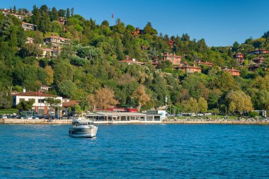Boğaz 'da bir tekne. İstanbul 'daki Boğaz kıyısında arka planda motorlu tekne. Turistik yerler. İstanbul. Hindi. 09.25.2021.