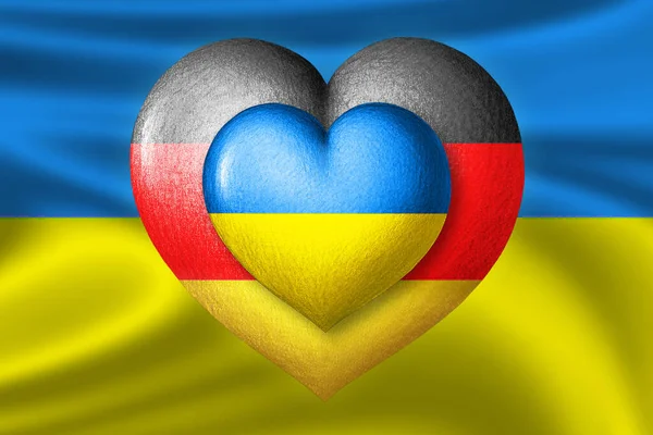 Flags of Ukraine and Germany. Two hearts in the colors of the flags on the background of the flag of Ukraine. Protection, solidarity and help concept. Cooperation of countries.