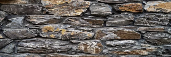 Stone wall. Wall of large hewn wild stone. Stone background. Texture of stone for creativity. Background for web design.