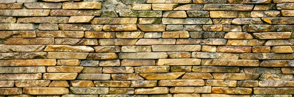 Stone wall. The wall is made of large hewn wild stone. Stone background. The texture of the stone for creativity. Background for web design.