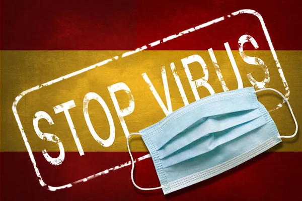 Lettering stamp Stop Virus and medical mask on Spain flag. Return of the coronavirus. New jump in incidence. Strain Omicron and Dedta. Danger of a viral infection. Medical concept.