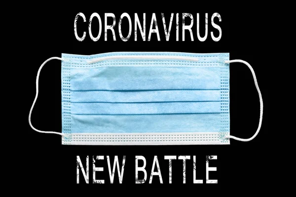 Medical mask. Lettering Coronavirus New Battle and medical Mask. Protection from respiratory infections. Isolate on black background. Danger of a viral infection. Health care and medical concept