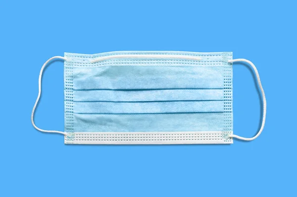 Medical mask. Disposable surgical mask. Protection from respiratory infections. Isolate on blue background. Danger of a viral infection. Health care and medical concept