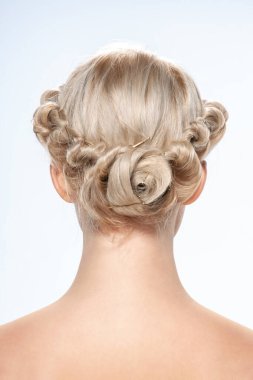 Genç bir kadının geçmişe bakış açısı. Çıplak beyaz bir sarışının portresi. Açık renkli saçlar. Şık bir saç modeli. Hafif bir arkaplanda izole edilmiş