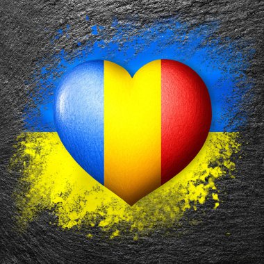 Ukrayna ve Romanya bayrakları. Ukrayna bayrağının arka planında bir taşa boyanmış bayrak kalbi. Koruma ve dayanışma kavramı. Askeri ve insani yardım.