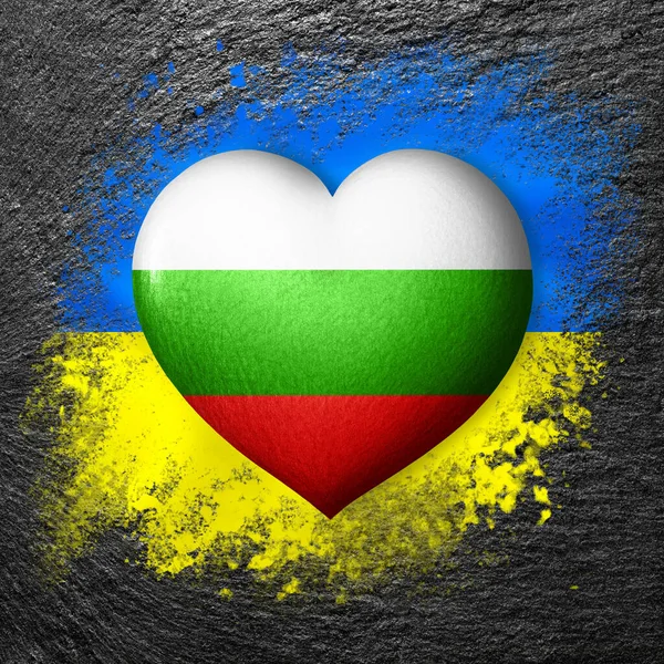 Flags of Ukraine and Bulgaria. Flag heart on the background of the flag of Ukraine painted on a stone. The concept of protection and solidarity. Military and humanitarian assistance.