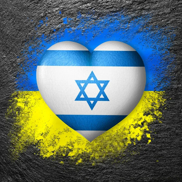 Flags of Ukraine and Israel. Flag heart on the background of the flag of Ukraine painted on a stone. The concept of protection and solidarity. Military and humanitarian assistance.