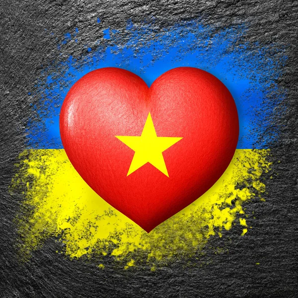Flags of Ukraine and Vietnam. Flag heart on the background of the flag of Ukraine painted on a stone. The concept of protection and solidarity. Military and humanitarian assistance.