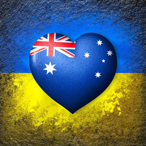 Flags of Ukraine and Australia. Flag heart on the background of the Ukrainian flag painted on a stone. The concept of protection and solidarity. Military and humanitarian assistance.
