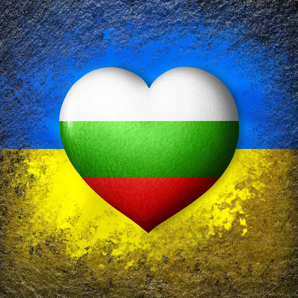 Flags of Ukraine and Bulgaria. Flag heart on the background of the Ukrainian flag painted on a stone. The concept of protection and solidarity. Military and humanitarian assistance.