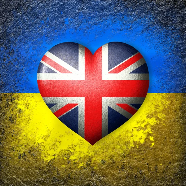 Flags of Ukraine and Great Britain. Flag heart on the background of the Ukrainian flag painted on a stone. The concept of protection and solidarity. Military and humanitarian assistance.