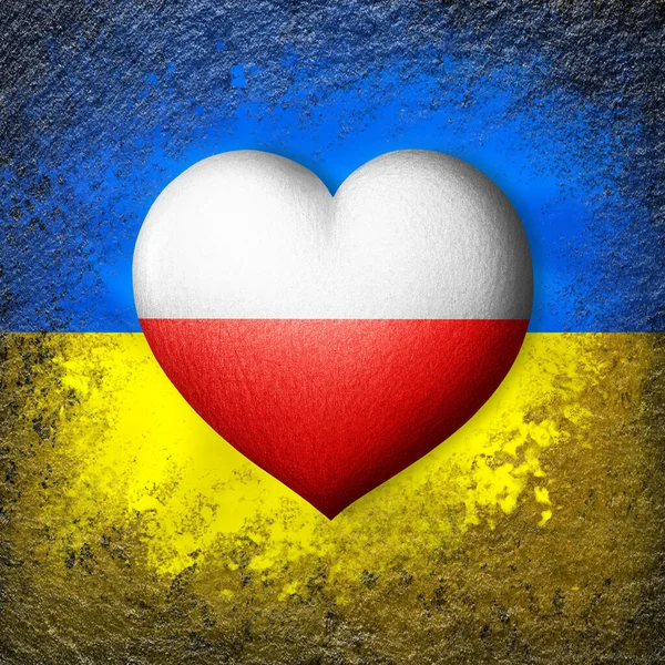 Flags of Ukraine and Poland. Flag heart on the background of the Ukrainian flag painted on a stone. The concept of protection and solidarity. Military and humanitarian assistance.
