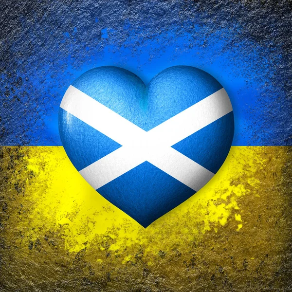 Flags of Ukraine and Scotland. Flag heart on the background of the Ukrainian flag painted on a stone. The concept of protection and solidarity. Military and humanitarian assistance.