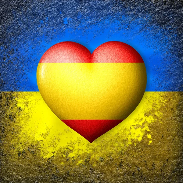 Flags of Ukraine and Spain. Flag heart on the background of the Ukrainian flag painted on a stone. The concept of protection and solidarity. Military and humanitarian assistance.