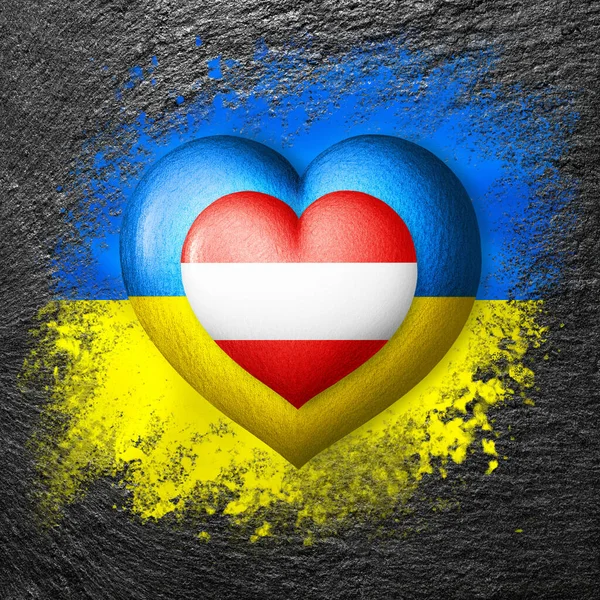 Flags of Ukraine and Austria. Two hearts in the colors of the flags are painted on the stone. Concept of protection, solidarity, cooperation and assistance of countries
