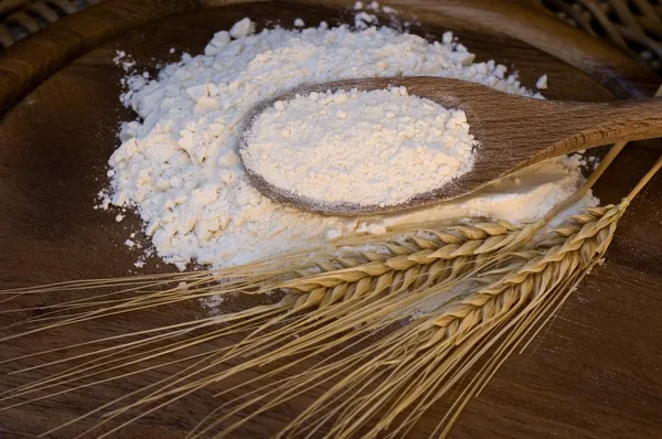Белая мука с пшеничными ушами — стоковое фото