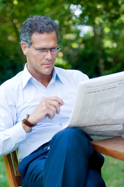 Reifer Mann liest Nachrichten — Stockfoto