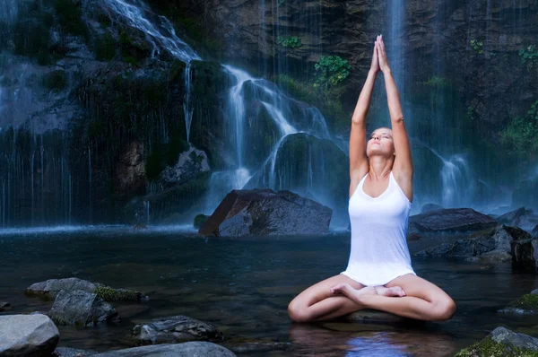 Yoga oefeningen in de buurt van waterval — Stockfoto