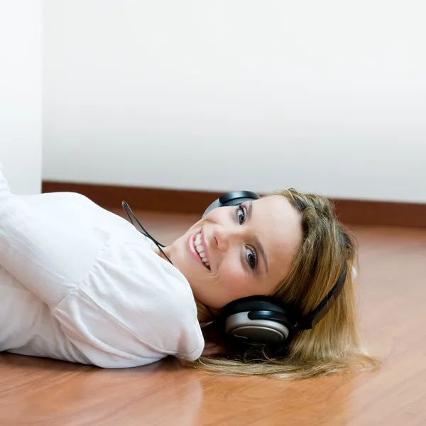 Jonge lachende vrouw luisteren muziek — Stockfoto