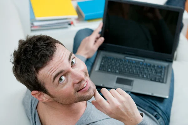 Sonriente hombre casual en el ordenador portátil — Foto de Stock