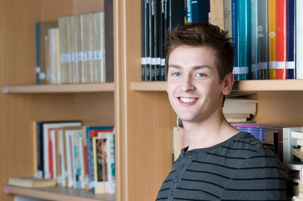 Glücklicher Student in einer Bibliothek — Stockfoto