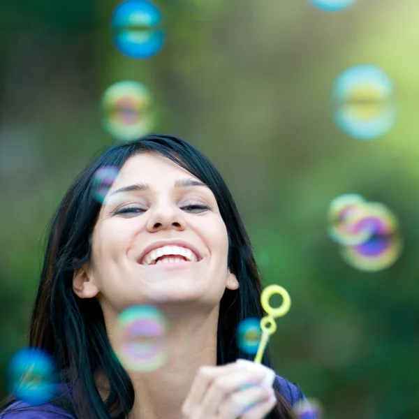 Smiling lady blowing bubbles — Stock Photo, Image