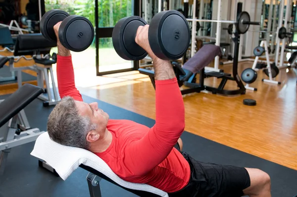 Mature man lifting weights Royalty Free Stock Photos